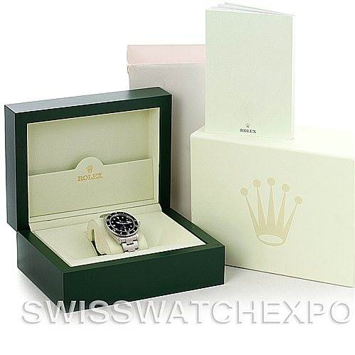 The image shows a Rolex Submariner 16610 Men
s Stainless Steel Black Dial 16610 Men
s Stainless Steel Black Dial watch in an open green box with accompanying packaging and documentation.
