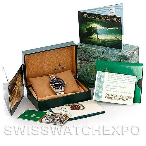 The image shows a Rolex Submariner 16613 Men
s Steel and Gold (two tone) Black Dial 16613 Men
s Steel and Gold (two tone) Black Dial watch at an angle inside an open box with its accessories, including manuals and certification cards.