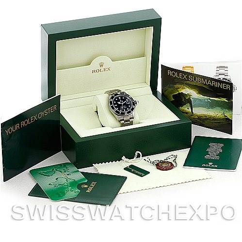 The image shows a Rolex Submariner 16610 Men
s Stainless Steel Black Dial 16610 Men
s Stainless Steel Black Dial watch featured in its open green box with accompanying booklets and accessories.