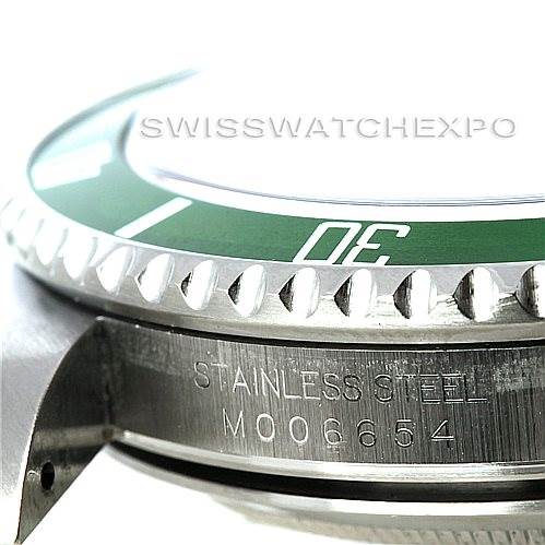 The image shows a close-up side view of a Rolex Submariner 16610LV Men
s Stainless Steel Black Dial 16610LV Men
s Stainless Steel Black Dial, focusing on the green bezel, the edge of the dial, and the engraved case side.