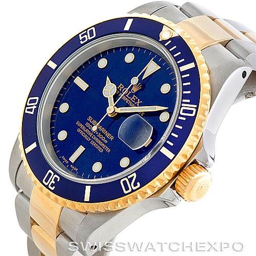 The image shows a Rolex Submariner 16613 Men's Steel and Gold (two tone) Blue Dial 16613 Men's Steel and Gold (two tone) Blue Dial watch at an angled view, highlighting its blue dial, gold bezel, and stainless steel and gold bracelet.