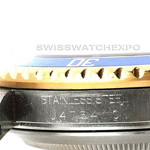This close-up image shows part of the bezel and case side of a Rolex Submariner 16613 Men's Steel and Gold (two tone) Blue Dial 16613 Men's Steel and Gold (two tone) Blue Dial watch with the engraving "STAINLESS STEEL" and a serial number.