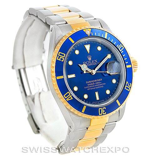 The image shows a Rolex Submariner 16613 Men's Steel and Gold (two tone) Blue Dial 16613 Men's Steel and Gold (two tone) Blue Dial watch at a slight angle, highlighting its blue dial, blue bezel, and two-tone metal bracelet.