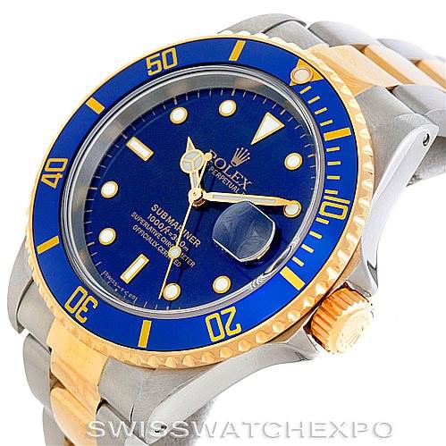 The image shows a Rolex Submariner 16613 Men's Steel and Gold (two tone) Blue Dial 16613 Men's Steel and Gold (two tone) Blue Dial watch from an angle highlighting the face, bezel, crown, and part of the bracelet.