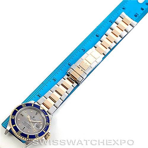 The image shows a top view of a Rolex Submariner 16613 Men
s Steel and Gold (two tone) Grey Dial 16613 Men
s Steel and Gold (two tone) Grey Dial watch, highlighting its blue and gold bezel and two-tone metal bracelet.
