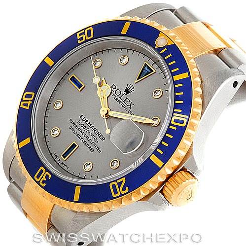 The image shows a Rolex Submariner 16613 Men
s Steel and Gold (two tone) Grey Dial 16613 Men
s Steel and Gold (two tone) Grey Dial watch at a slight angle, displaying the dial, bezel, and part of the bracelet and crown.