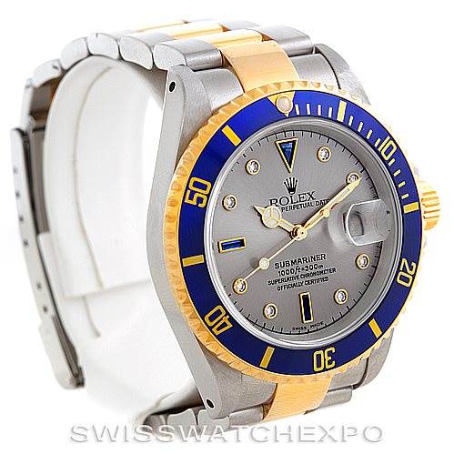 The image shows a Rolex Submariner 16613 Men
s Steel and Gold (two tone) Grey Dial 16613 Men
s Steel and Gold (two tone) Grey Dial watch at a three-quarter angle, highlighting the bezel, dial, and bracelet.