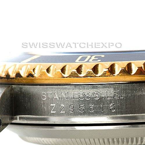 Close-up of a Rolex Submariner 16613 Men's Steel and Gold (two tone) Black Dial 16613 Men's Steel and Gold (two tone) Black Dial watch showing the bezel edge, part of the dial, and the stainless steel casing with the serial number.