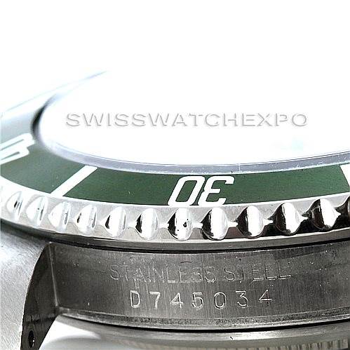 The image shows a side angle of a Rolex Submariner 16610T Men
s Stainless Steel Black Dial 16610T Men
s Stainless Steel Black Dial watch, focusing on the edge of the bezel and the serial number on the case.