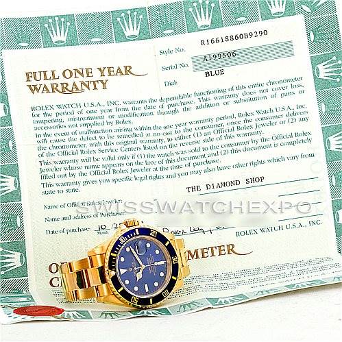 The image shows a Rolex Submariner 16618 Men's Yellow Gold Blue Dial 16618 Men's Yellow Gold Blue Dial watch placed on top of its warranty card, photographed from an overhead angle.