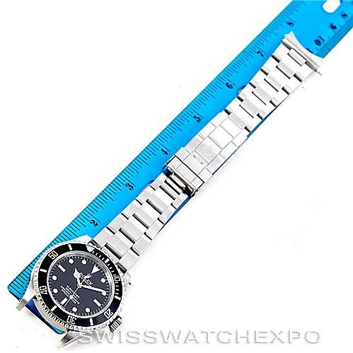 The image shows a Rolex Submariner 14060 Men
s Stainless Steel Black Dial 14060 Men
s Stainless Steel Black Dial watch laid flat from a top-down angle, next to a blue ruler measuring the length of the bracelet.