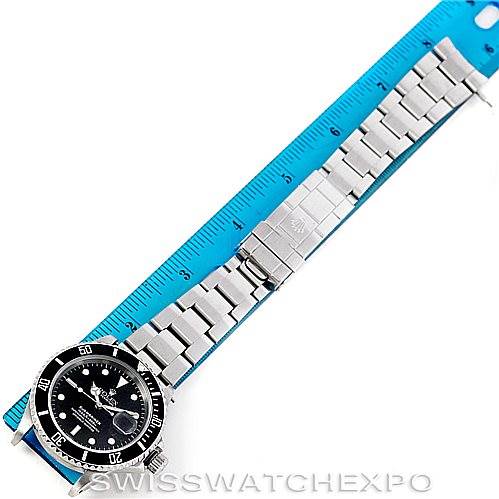 The image shows a top-down view of a Rolex Submariner 16610 Men
s Stainless Steel Black Dial 16610 Men
s Stainless Steel Black Dial watch fully extended next to a blue ruler for scale.