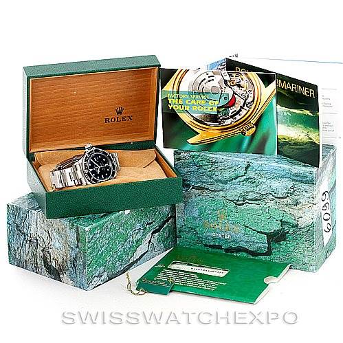 The image shows a Rolex Submariner 16610 Men
s Stainless Steel Black Dial 16610 Men
s Stainless Steel Black Dial watch in its open box, along with the outer box, manuals, and tags arranged around it.