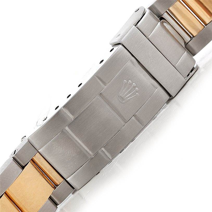 The image shows a close-up of the clasp and bracelet of a Rolex Submariner 16613 Men's Steel and Gold (two tone) Black Dial 16613 Men's Steel and Gold (two tone) Black Dial watch, featuring a two-tone design with stainless steel and gold.