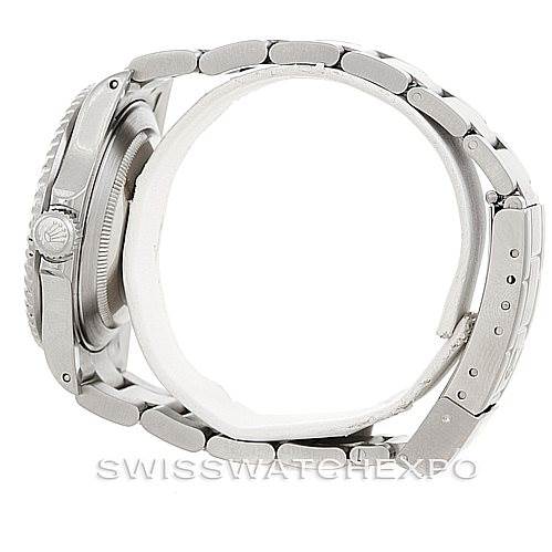 This side view of the Rolex Submariner 16610 Men's Stainless Steel Black Dial 16610 Men's Stainless Steel Black Dial shows the watch case, crown, and metal bracelet.