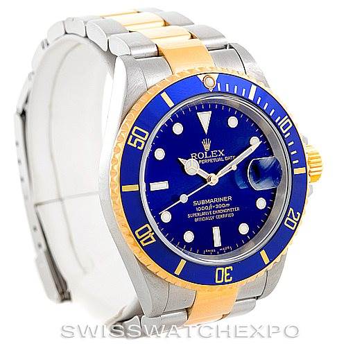 The image shows a Rolex Submariner 16613 Men's Steel and Gold (two tone) Blue Dial 16613 Men's Steel and Gold (two tone) Blue Dial watch from an oblique angle, highlighting its blue dial, bezel, and two-tone bracelet.