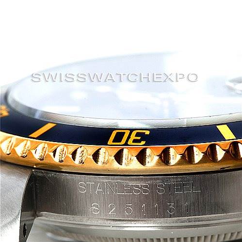 The image shows a close-up side angle of a Rolex Submariner 16613 Men
s Steel and Gold (two tone) Black Dial 16613 Men
s Steel and Gold (two tone) Black Dial watch, focusing on its bezel and part of the case with visible engravings.