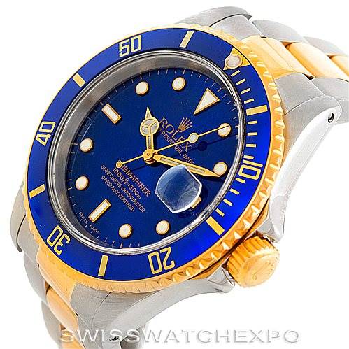 The image shows a Rolex Submariner 16613 Men's Steel and Gold (two tone) Blue Dial 16613 Men's Steel and Gold (two tone) Blue Dial watch at an angled view, highlighting its blue dial, gold accents, bezel, and crown.