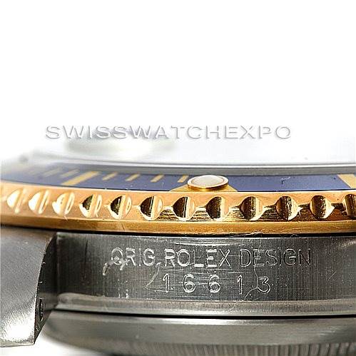 The image shows a close-up, side view of a Rolex Submariner 16613 Men
s Steel and Gold (two tone) Blue Dial 16613 Men
s Steel and Gold (two tone) Blue Dial watch, highlighting the bezel, case, and model engravings (16613).
