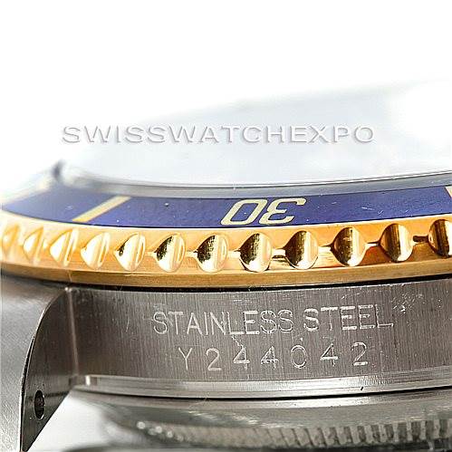 The image shows a close-up side view of a Rolex Submariner 16613 Men's Steel and Gold (two tone) Grey Dial 16613 Men's Steel and Gold (two tone) Grey Dial watch, highlighting the bezel, stainless steel case, and serial number.