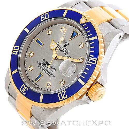 The image shows a Rolex Submariner 16613 Men's Steel and Gold (two tone) Grey Dial 16613 Men's Steel and Gold (two tone) Grey Dial watch from an angled side view, highlighting its dial, bezel, crown, and part of the bracelet.