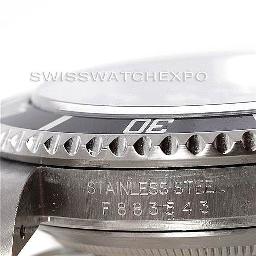This close-up image of a Rolex Submariner 16610 Men's Stainless Steel Black Dial 16610 Men's Stainless Steel Black Dial showcases the bezel and part of the case, highlighting the stainless steel material and serial number.