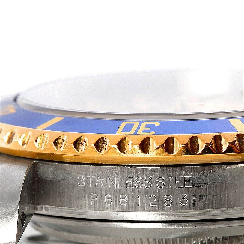 The image shows a close-up side view of a Rolex Submariner 16613 Men's Steel and Gold (two tone) Champagne Dial 16613 Men's Steel and Gold (two tone) Champagne Dial, focusing on its stainless steel case and part of the bezel.