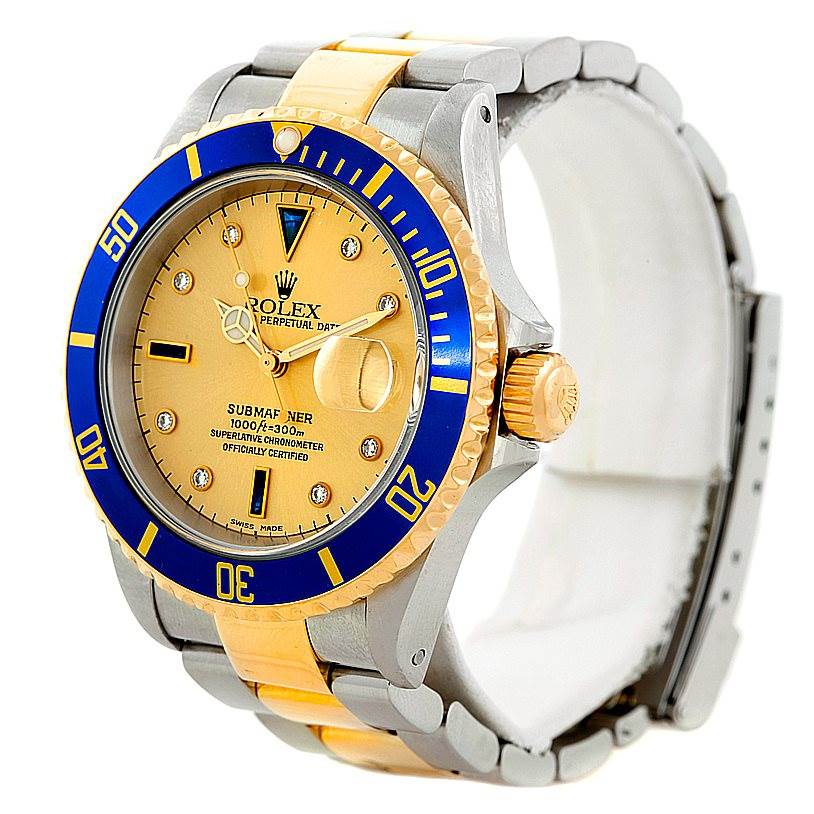 The image shows a Rolex Submariner 16613 Men's Steel and Gold (two tone) Champagne Dial 16613 Men's Steel and Gold (two tone) Champagne Dial watch viewed at an angle highlighting the dial, bezel, crown, and part of the bracelet.