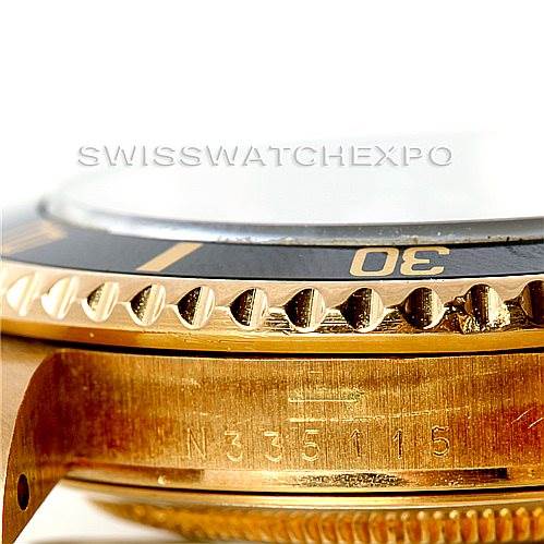 Close-up of the side of a Rolex Submariner 16618 Men
s Yellow Gold Black Dial 16618 Men
s Yellow Gold Black Dial, showing the bezel, part of the dial, and the engraving on the case.