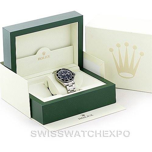 The image depicts a Rolex Submariner 16610 Men
s Stainless Steel Black Dial 16610 Men
s Stainless Steel Black Dial watch displayed in its green and beige case, with the outer box and manual visible.