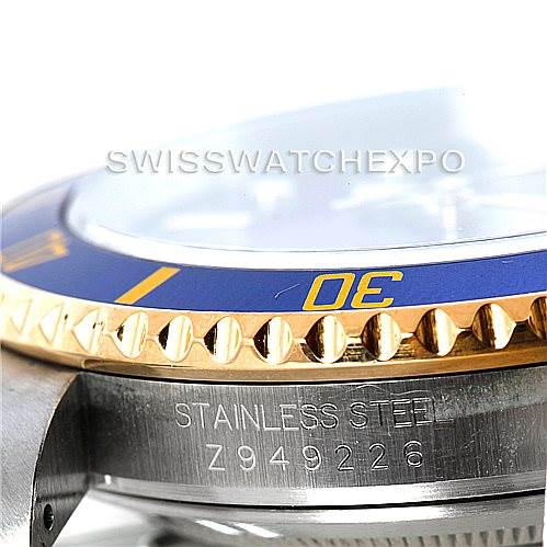 A close-up side view of a Rolex Submariner 16613 Men's Steel and Gold (two tone) Blue Dial 16613 Men's Steel and Gold (two tone) Blue Dial watch, highlighting the stainless steel case, engraved serial number, and blue and gold bezel.