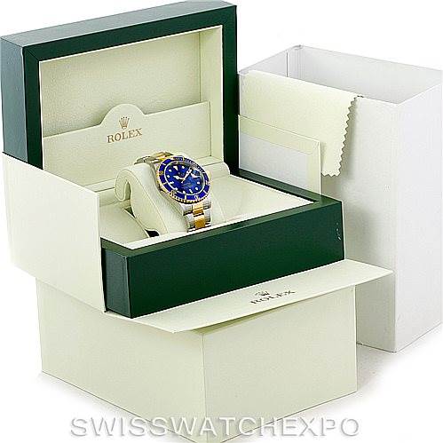 The image shows the Rolex Submariner 16613 Men's Steel and Gold (two tone) Blue Dial 16613 Men's Steel and Gold (two tone) Blue Dial watch placed in its open green box, alongside outer packaging.