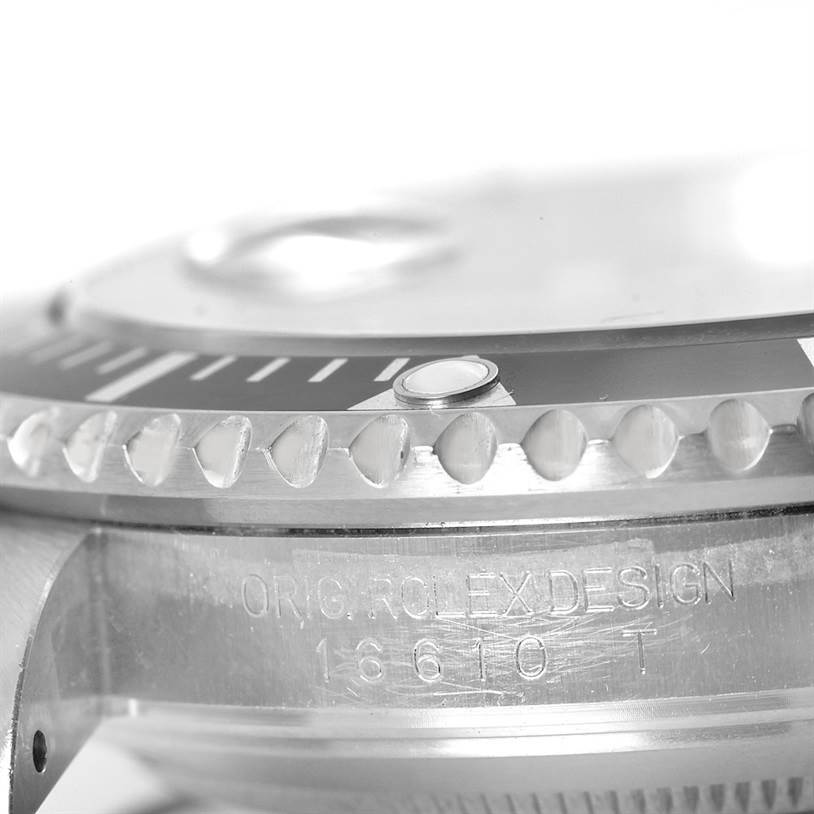 This close-up image of the Rolex Submariner 16610 Men
s Stainless Steel Black Dial 16610 Men
s Stainless Steel Black Dial watch showcases the bezel, indices, and engraved side of the case.