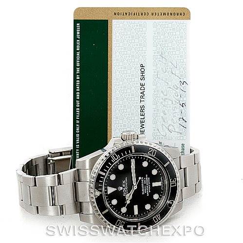 The image shows a Rolex Submariner 114060 Men
s Stainless Steel Black Dial 114060 Men
s Stainless Steel Black Dial watch placed upright with its stainless steel bracelet partially extended, accompanied by its certification card.