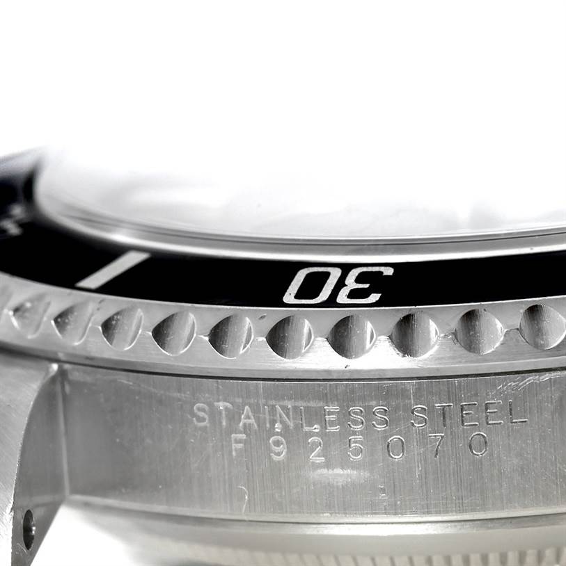 This image shows a close-up of the bezel, case, and part of the serial number of a Rolex Submariner 14060 Men
s Stainless Steel Black Dial 14060 Men
s Stainless Steel Black Dial watch.