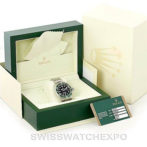 This image shows a Rolex Submariner 16610V Men
s Stainless Steel Black Dial 16610V Men
s Stainless Steel Black Dial watch from a front angle, along with its box, cleaning cloth, and warranty card.