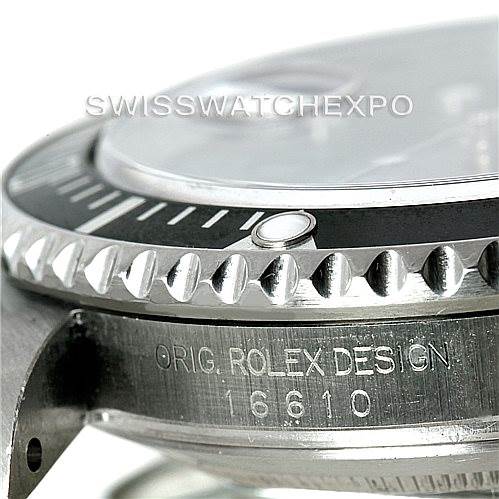 This close-up image shows the bezel, crystal, and part of the case with engraved text of a Rolex Submariner 16610 Men
s Stainless Steel Black Dial 16610 Men
s Stainless Steel Black Dial model 16610.