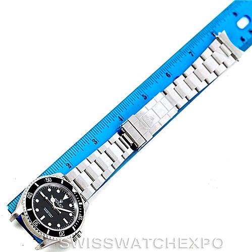 The image shows the entire Rolex Submariner 14060 Men
s Stainless Steel Black Dial 14060 Men
s Stainless Steel Black Dial watch, including the face, bezel, and full bracelet, laid next to a ruler for scale.