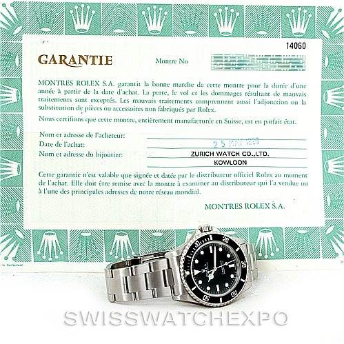 The image shows a Rolex Submariner 14060 Men
s Stainless Steel Black Dial 14060 Men
s Stainless Steel Black Dial watch along with its warranty card.