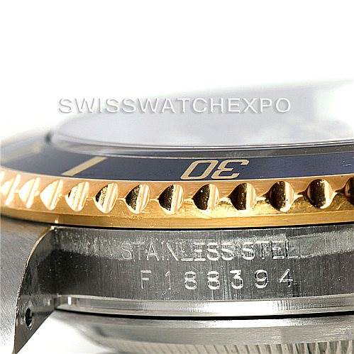 This image shows a close-up of the side view of a Rolex Submariner 16613 Men
s Steel and Gold (two tone) Blue Dial 16613 Men
s Steel and Gold (two tone) Blue Dial, focusing on the bezel and part of the stainless steel case with the serial number.