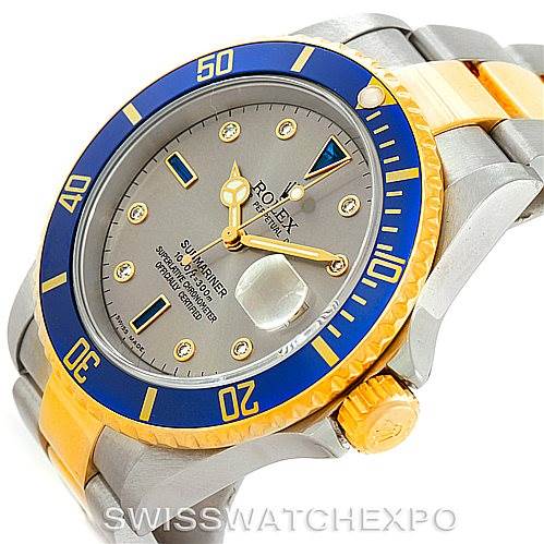 The image shows a Rolex Submariner 16613 Men's Steel and Gold (two tone) Grey Dial 16613 Men's Steel and Gold (two tone) Grey Dial model watch from an angled view, highlighting the bezel, dial, hands, and bracelet.