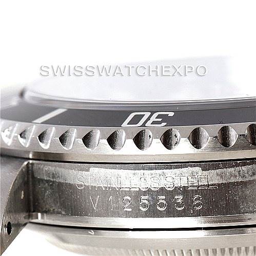 The image shows a close-up side view of a Rolex Submariner 16610 Men
s Stainless Steel Black Dial 16610 Men
s Stainless Steel Black Dial watch, focusing on its bezel and serial number.