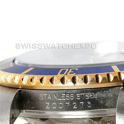The image shows a close-up angle of a Rolex Submariner 16613 Men
s Steel and Gold (two tone) Grey Dial 16613 Men
s Steel and Gold (two tone) Grey Dial watch, focusing on the bezel and the case side with the serial number.