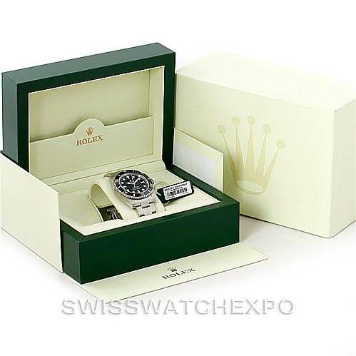 The image shows a Rolex Submariner 114060 Men
s Stainless Steel Black Dial 114060 Men
s Stainless Steel Black Dial watch inside its green presentation box with the lid open, placed next to the outer Rolex packaging.
