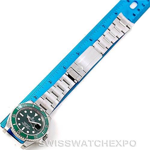 The image shows a Rolex Submariner 116610LV Men
s Stainless Steel Green Dial 116610LV Men
s Stainless Steel Green Dial watch lying flat next to a blue ruler, displaying the watch case and entire bracelet.