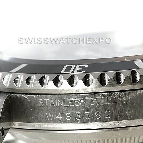 This close-up image shows the bezel and part of the case of the Rolex Submariner 16610 Men
s Stainless Steel Black Dial 16610 Men
s Stainless Steel Black Dial, including engraved serial numbers and "STAINLESS STEEL."