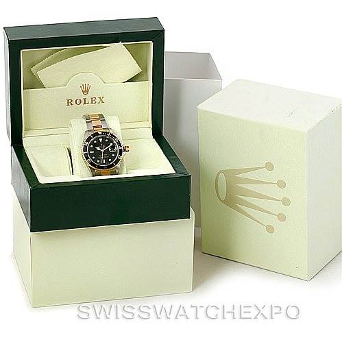 The Rolex Submariner 16613 Men's Steel and Gold (two tone) Black Dial 16613 Men's Steel and Gold (two tone) Black Dial watch is shown front-on inside its open green box, alongside its outer packaging.