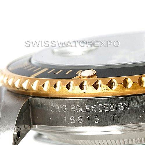 The image shows a close-up of the bezel, crystal, and part of the case of a Rolex Submariner 16613 Men's Steel and Gold (two tone) Black Dial 16613 Men's Steel and Gold (two tone) Black Dial model 16613 watch.