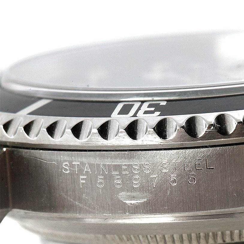 This image shows a close-up of the bezel, crystal, and part of the stainless steel case with the serial number of a Rolex Submariner 14060 Men
s Stainless Steel Black Dial 14060 Men
s Stainless Steel Black Dial watch.