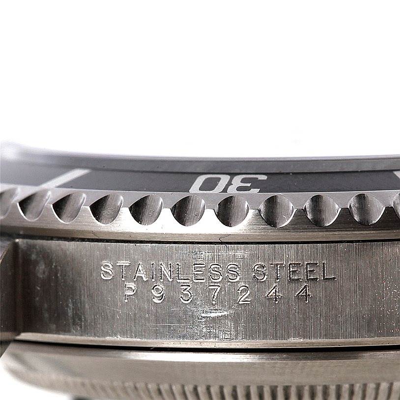 This close-up image shows the bezel and part of the case engraving of the Rolex Submariner 14060 Men
s Stainless Steel Black Dial 14060 Men
s Stainless Steel Black Dial watch, highlighting the "STAINLESS STEEL" and serial number.